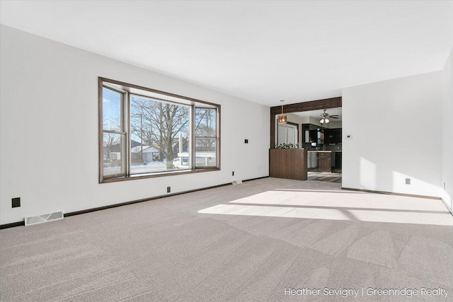 unfurnished living room featuring ceiling fan and light colored carpet