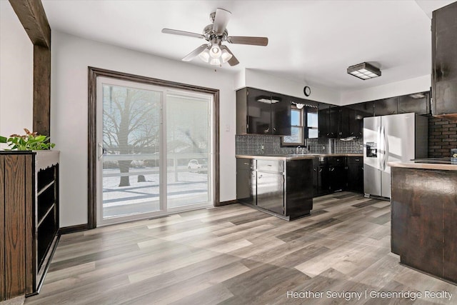 kitchen with backsplash, ceiling fan, light hardwood / wood-style floors, and stainless steel refrigerator with ice dispenser