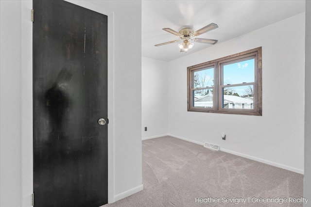 spare room with ceiling fan and light carpet