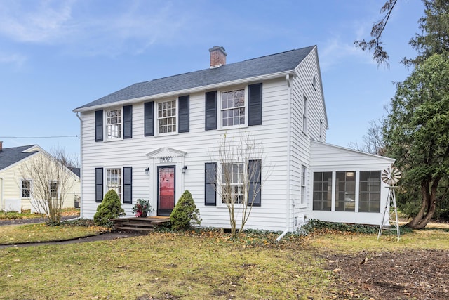 colonial-style house with a front yard and a sunroom