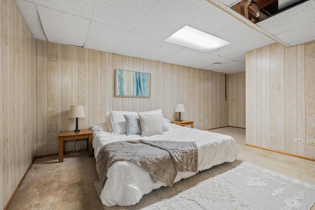 bedroom with a paneled ceiling and wooden walls