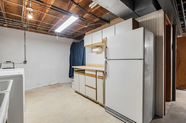 basement featuring white refrigerator and washer / clothes dryer