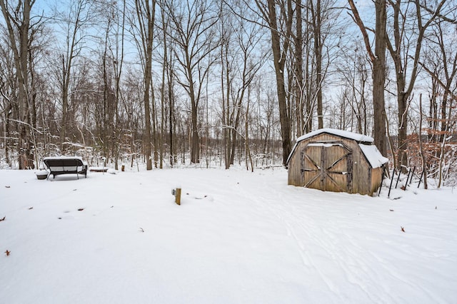 snowy yard with a storage shed