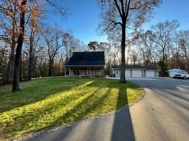 view of front of home with covered porch, a garage, and a front yard