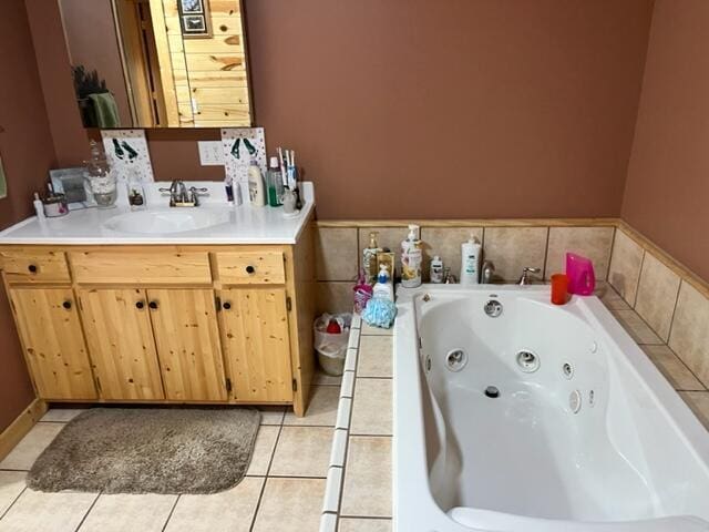 bathroom with tile patterned floors, a tub, and vanity