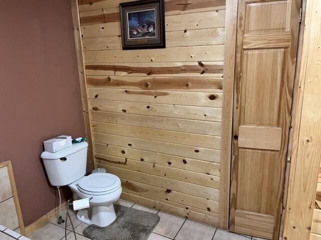 bathroom featuring tile patterned flooring, toilet, and wooden walls