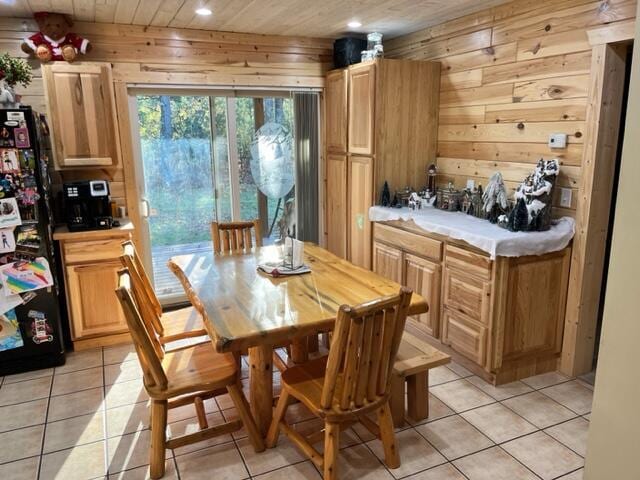 dining space with wood walls, light tile patterned floors, and wood ceiling