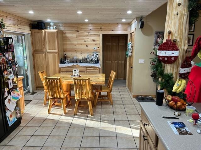 dining room with wooden ceiling, wooden walls, and light tile patterned flooring