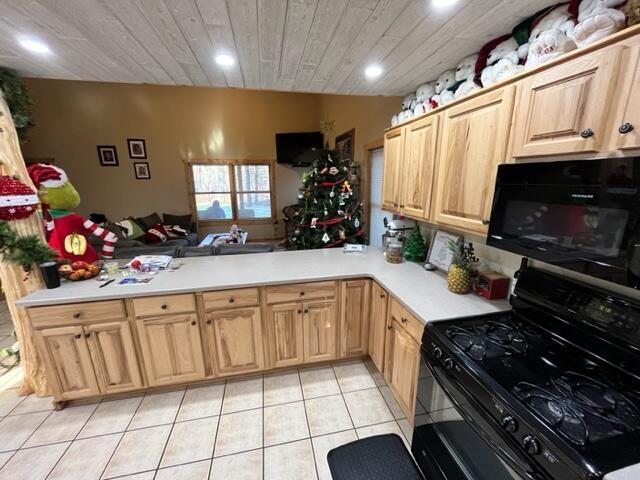 kitchen with black appliances, kitchen peninsula, light tile patterned floors, light brown cabinetry, and wood ceiling