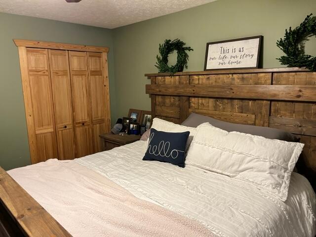 bedroom with a textured ceiling and a closet