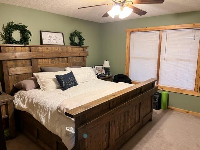 carpeted bedroom with a textured ceiling and ceiling fan