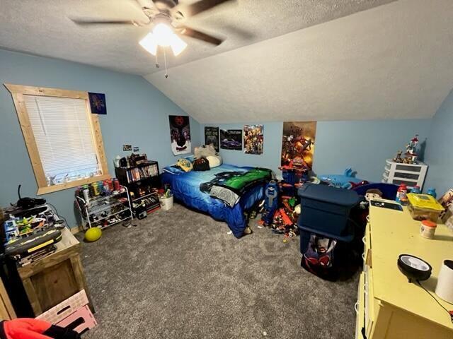 bedroom with carpet flooring, a textured ceiling, ceiling fan, and lofted ceiling