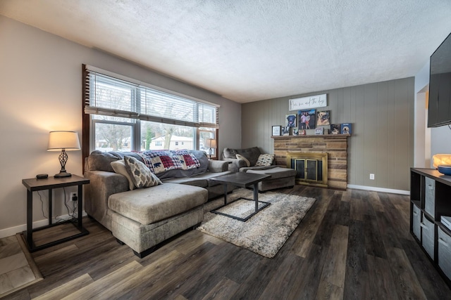 living room with a fireplace, dark wood-type flooring, and a textured ceiling