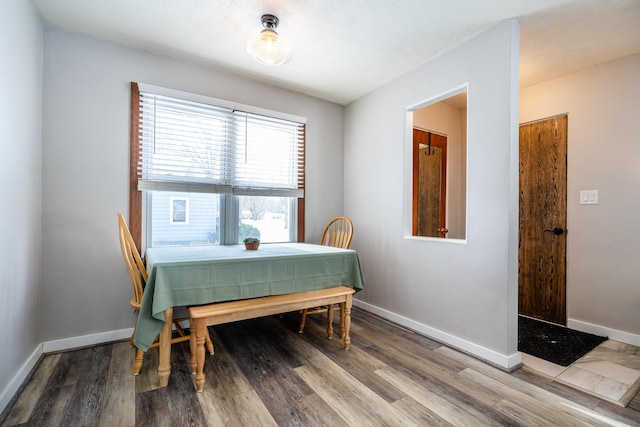 dining space with hardwood / wood-style floors and a textured ceiling