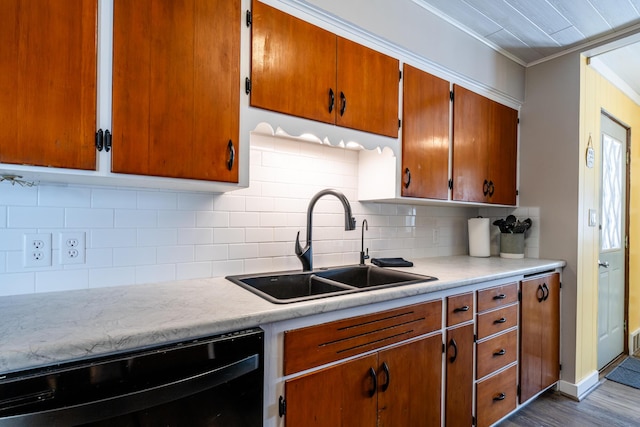 kitchen with sink, dishwasher, tasteful backsplash, ornamental molding, and light wood-type flooring