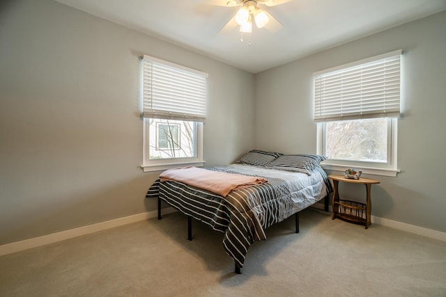 carpeted bedroom featuring multiple windows and ceiling fan