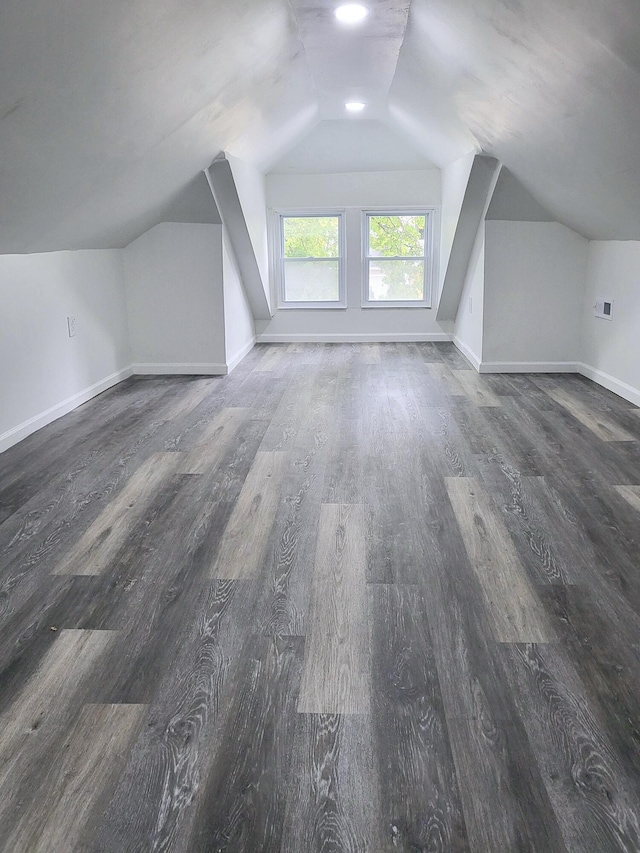 bonus room with dark hardwood / wood-style flooring and vaulted ceiling