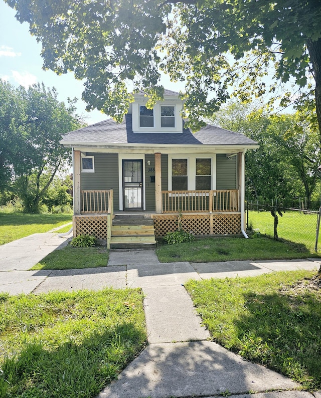 bungalow with covered porch and a front lawn