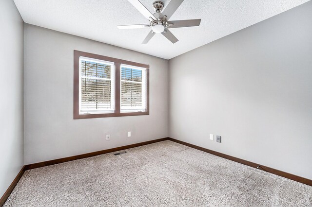 carpeted spare room featuring ceiling fan and a textured ceiling