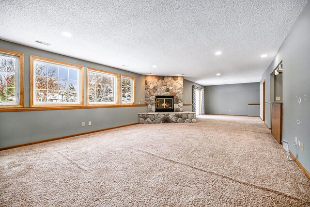 unfurnished living room with a fireplace, carpet floors, and a textured ceiling