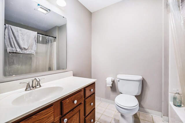 bathroom with toilet, vanity, and tile patterned floors