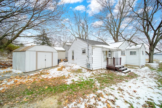 snow covered property with a storage shed