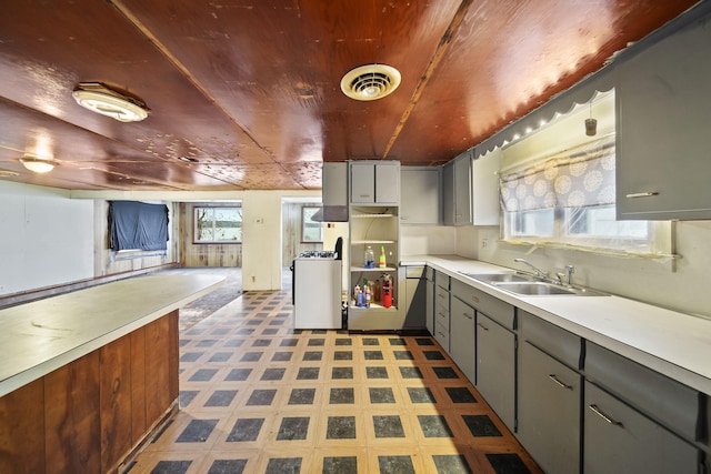 kitchen with gray cabinets, white range oven, sink, and a wealth of natural light