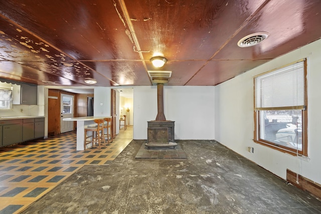 unfurnished living room with a wood stove and a healthy amount of sunlight