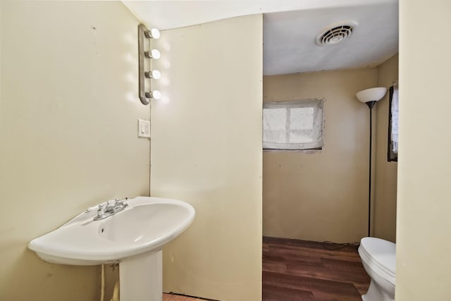 bathroom featuring wood-type flooring and toilet