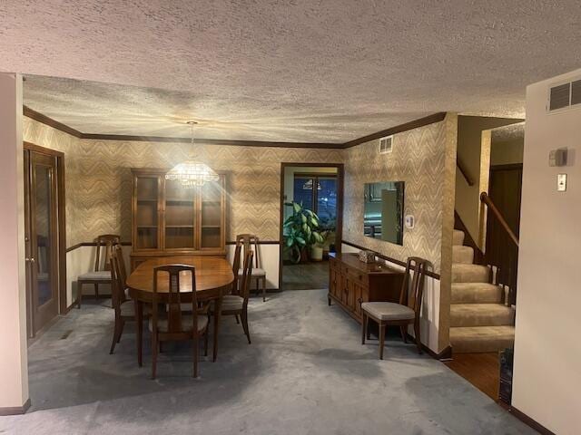 dining area featuring crown molding, a textured ceiling, and a notable chandelier