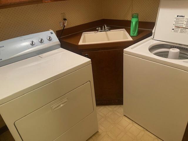 laundry area featuring washing machine and clothes dryer and sink