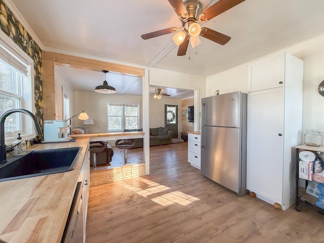 kitchen with sink, white cabinetry, stainless steel appliances, and wooden counters