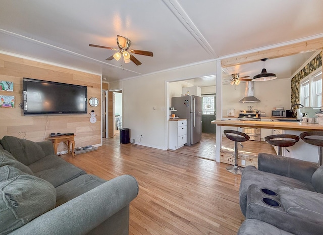 living room with a wealth of natural light, sink, ceiling fan, and light hardwood / wood-style floors