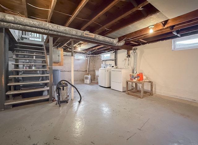 basement with electric panel and washing machine and clothes dryer