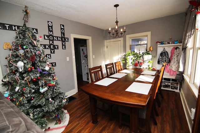 dining space with a notable chandelier, dark hardwood / wood-style floors, and a textured ceiling