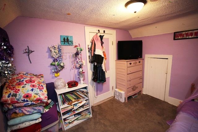 carpeted bedroom with a textured ceiling and vaulted ceiling