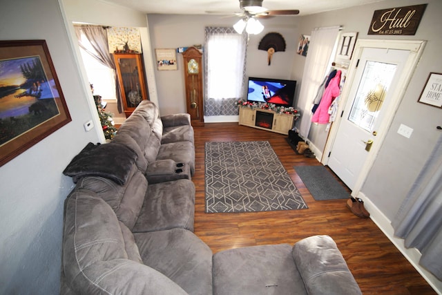 living room featuring ceiling fan and dark wood-type flooring