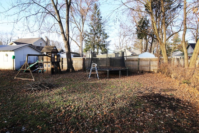 view of yard with a playground and a trampoline