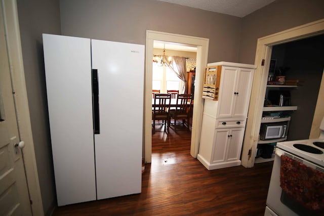 kitchen featuring white cabinetry, dark wood-type flooring, an inviting chandelier, a textured ceiling, and white appliances