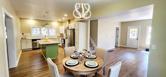 dining space featuring sink, hardwood / wood-style floors, and a notable chandelier