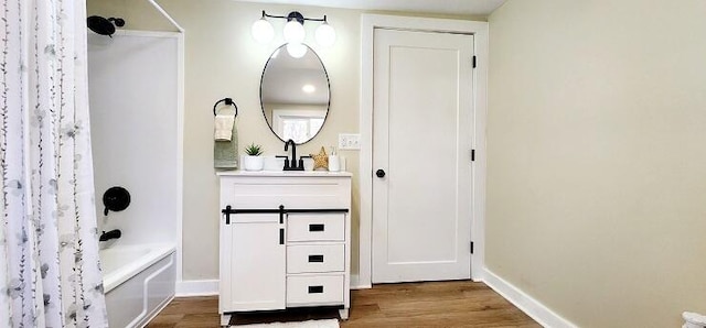 bathroom with hardwood / wood-style floors, vanity, and shower / bath combo with shower curtain