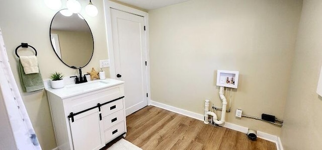 laundry area featuring washer hookup, light hardwood / wood-style floors, and sink