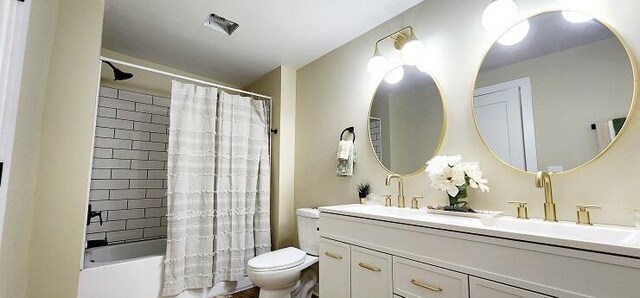 full bathroom featuring vanity, shower / tub combo, and toilet