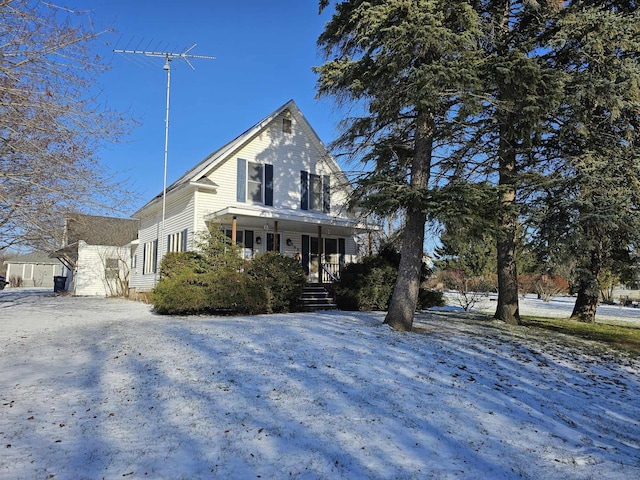 snow covered property with covered porch