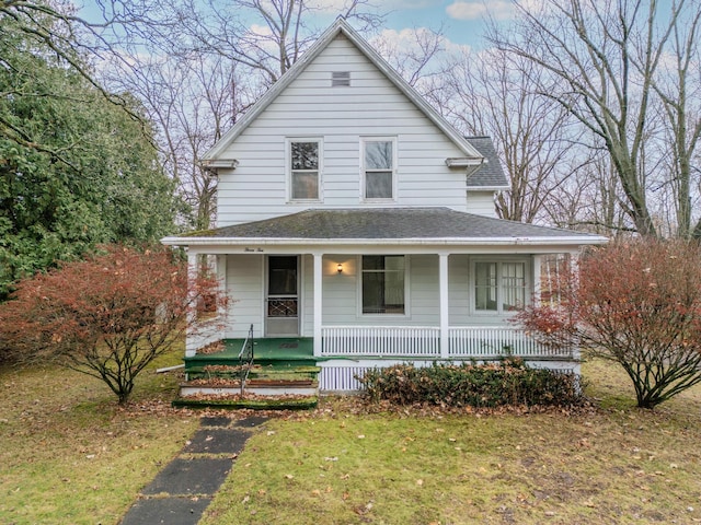 farmhouse-style home with covered porch and a front lawn