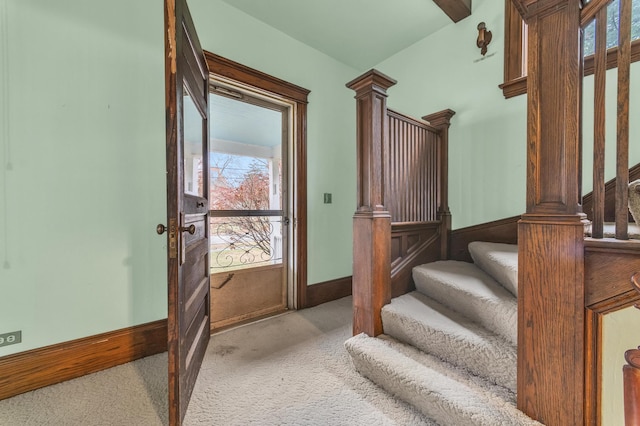 stairway with carpet and decorative columns