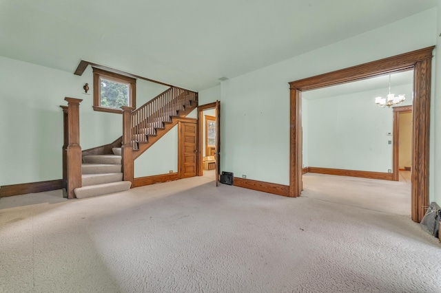 unfurnished living room with carpet flooring and an inviting chandelier