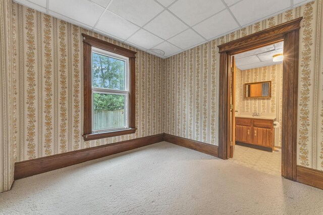 carpeted spare room with a paneled ceiling