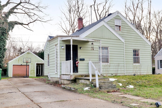 bungalow-style house featuring a garage, an outdoor structure, and a front lawn