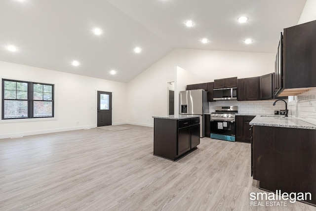 kitchen featuring a center island, high vaulted ceiling, sink, light hardwood / wood-style flooring, and appliances with stainless steel finishes